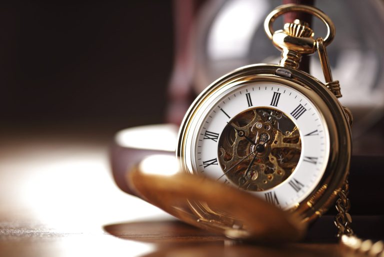 Eine aufgeschlagene Taschenuhr mit goldener Hülle und einem komplexen Zifferblatt.